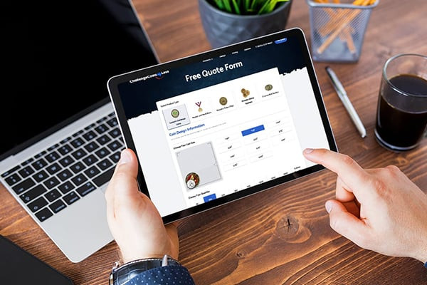 A person in business attire is using a tablet with a 'Free Quote Form' from the challengecoins4less.com coin company's website, showcasing the ease of requesting custom coin designs online