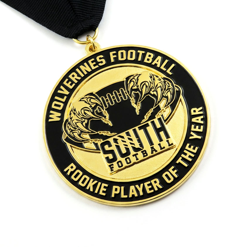 Gold and black Wolverines Football South Rookie Player of the Year medal with wolverine claws gripping a football and black ribbon