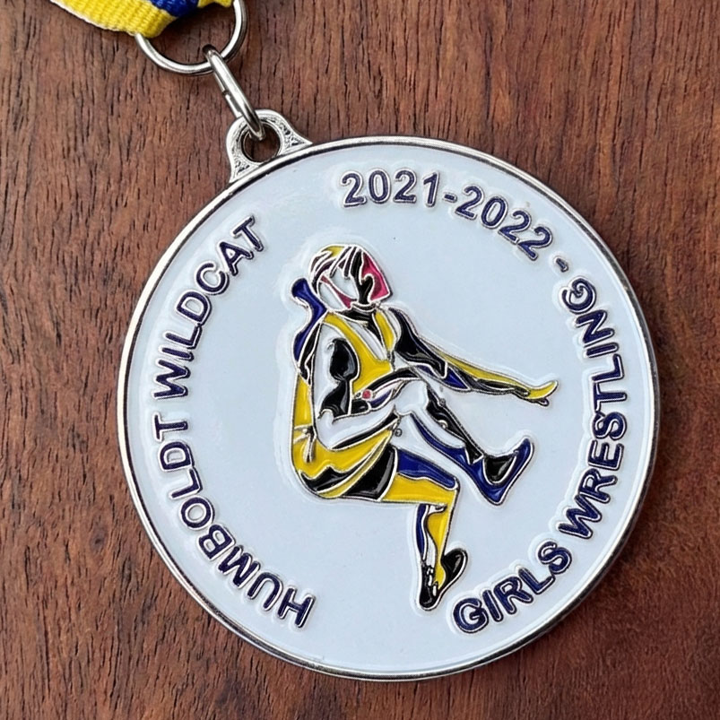 Silver Humboldt Wildcat Girls Wrestling 2021-2022 medal with enamel wrestler silhouette in yellow and blue on yellow and blue ribbon
