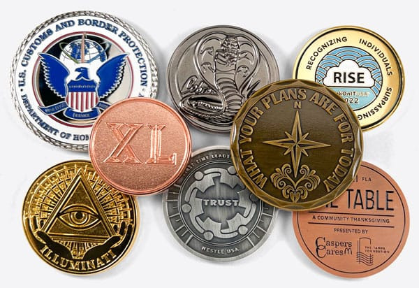 pile of challenge coins with different metal finishes